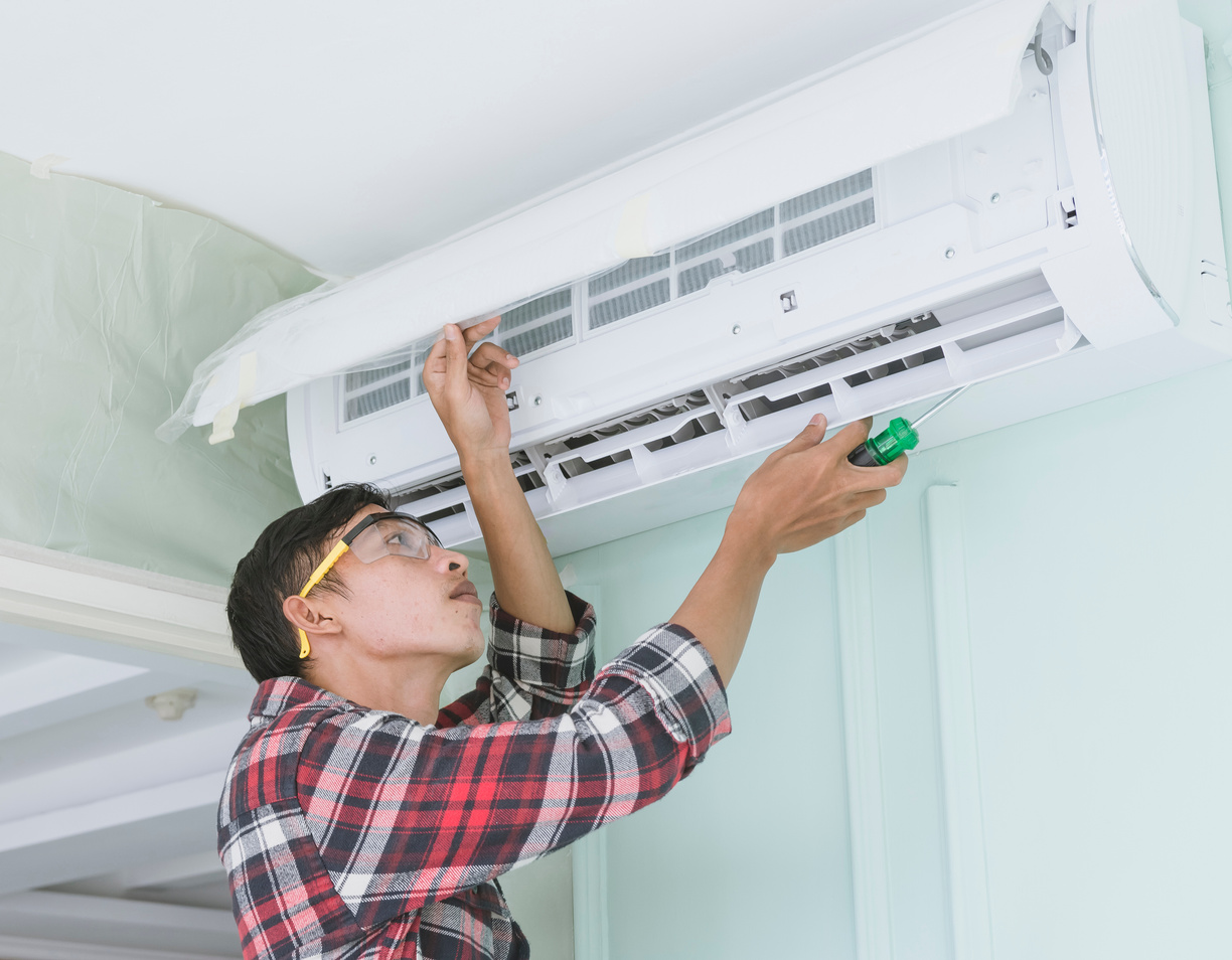 Repairman Inspecting an Air Conditioning Unit